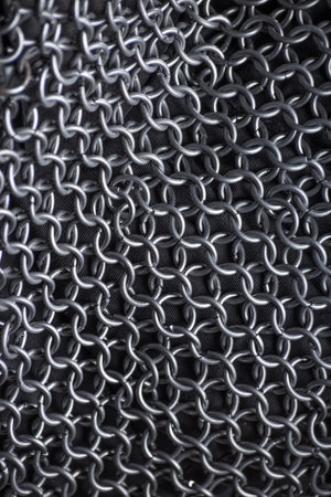 Intricate Close-Up of Medieval Chainmail Fabric. Detailed texture of interconnected metal rings forming a protective armor layer.の写真素材