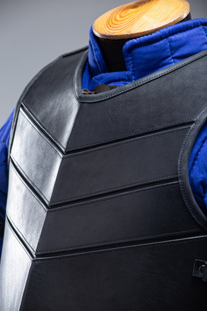 Black Leather Body Armor with Adjustable Straps. This image features a black leather torso armor with a segmented design on the chest and adjustable straps with buckles on the sides.の写真素材