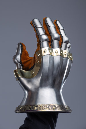 Silver Hourglass Gauntlets with Brass Details. This image shows a close-up of a pair of shiny silver hourglass gauntlets, featuring articulated fingers and brass accents along the edges and rivets.の写真素材