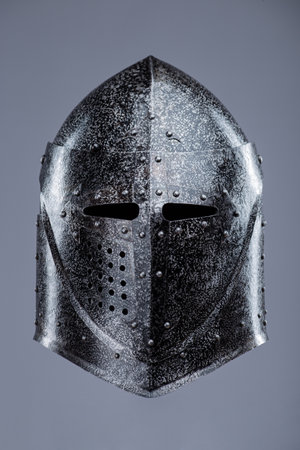 Closed Medieval Knight's Helmet with Small Perforations. This image shows a closed medieval knight's helmet, likely made of steel, with a pointed top and small perforations for ventilation and vision.の写真素材