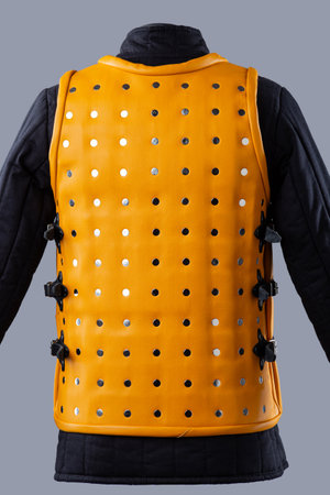 Bright Yellow Brigandine Armor with Studs. This image shows a bright yellow brigandine armor, featuring rows of silver studs and black straps with buckles on the sides.の写真素材