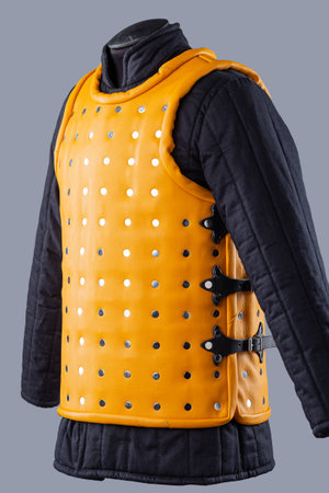 Bright Yellow Brigandine Armor with Studs. This image shows a bright yellow brigandine armor, featuring rows of silver studs and black straps with buckles on the sides.の写真素材