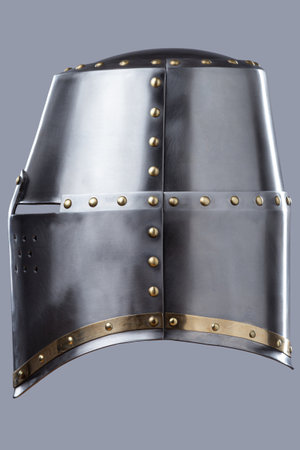 Silver Great Helm with Ventilation Holes. This image shows a shiny silver great helm, a type of medieval helmet, with a flat top, narrow eye slits, and numerous small ventilation holes on the front.の写真素材