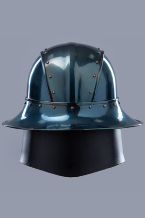 Dark Metal Helmet with Wide Brim and Grill Visor. This image shows a dark, possibly gunmetal grey, helmet with a wide, slightly sloping brim and a black grill-like visor covering the face.の写真素材
