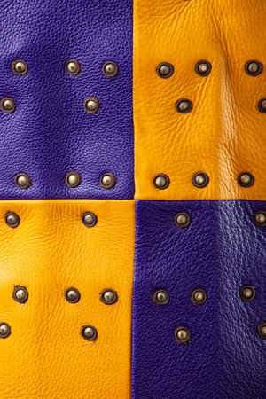 Extreme Close-Up of Colorful Brigandine Armor Texture. This image presents an extreme close-up of the colorful brigandine armor, highlighting the texture of the purple and yellow leather and the pattern of the studs.の写真素材