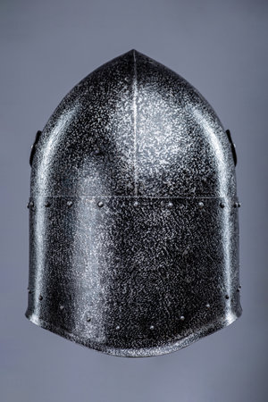 Closed Medieval Knight's Helmet with Small Perforations. This image shows a closed medieval knight's helmet, likely made of steel, with a pointed top and small perforations for ventilation and vision.の写真素材