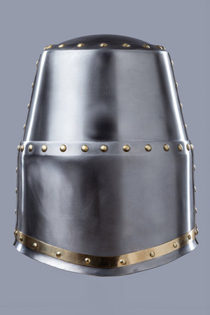 Silver Great Helm with Ventilation Holes. This image shows a shiny silver great helm, a type of medieval helmet, with a flat top, narrow eye slits, and numerous small ventilation holes on the front.の写真素材