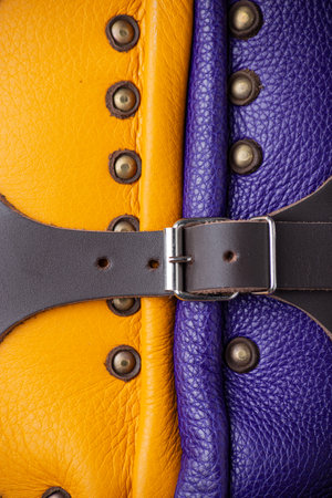 Close-Up of Colorful Brigandine Armor Details. This image provides a detailed close-up of the colorful brigandine armor, showcasing the studs, leather straps with buckles, and the contrasting purple and yellow sections.の写真素材