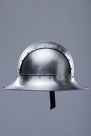 Silver Helmet with Wide Brim and Rivets. This image shows a shiny silver helmet featuring a wide, downward-sloping brim and several small rivets along its edges and the crown.の写真素材