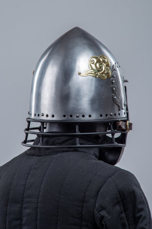Silver Helmet with Decorative Face Mask. Unique medieval head protection with golden accentsの写真素材