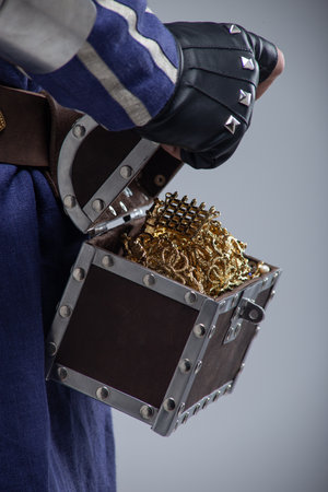 Open Treasure Chest Overflowing with Gold. Close-up of a hand revealing a bounty of jewelry and coins.の写真素材