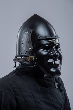Black Steel Helmet with Face Mask. Grotesque medieval head protection with decorative wings.の写真素材