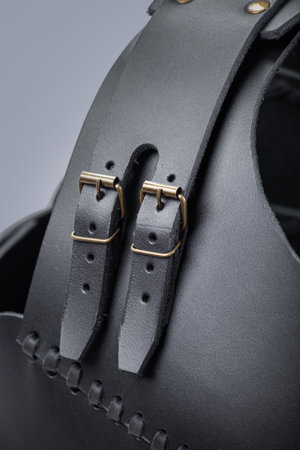 Close-up of Leather Straps and Buckles on Black Cuirass. Detailed view of the adjustable fastenings on medieval torso armor.の写真素材
