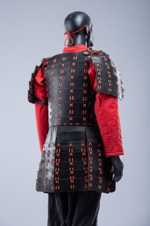 Black and Red Leather Armor Set on Mannequin. Full medieval warrior outfit with detailed stitching and metal accents.の写真素材