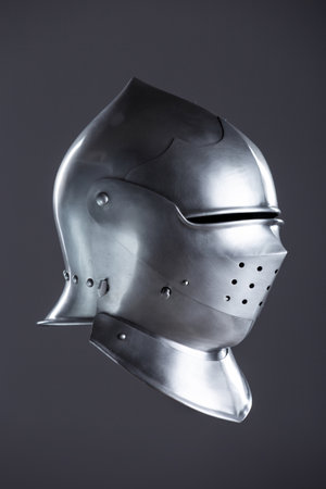 Polished Silver Medieval Armet Helmet with Perforated Visor. This shiny silver armet features a rounded skull, a protective bevor, and a visor with multiple small perforations.の写真素材