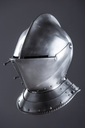 Shiny Silver Medieval Armet Helmet with Visor. This polished silver armet features a hinged visor and bevor, offering full head protection in medieval style.の写真素材