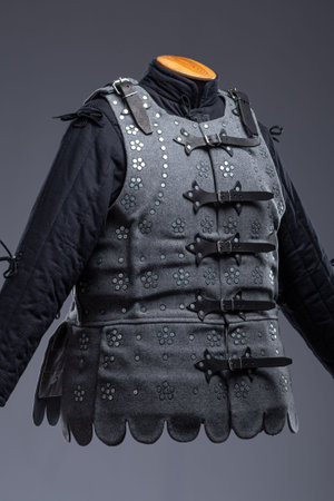 Gray Medieval Brigandine Armor with Leather Straps. This gray brigandine features overlapping metal plates riveted to a fabric base, secured with leather straps.の写真素材