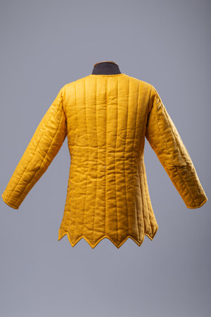 Yellow Padded Gambeson Jacket. Medieval quilted under-armor with leather strap closures.の写真素材
