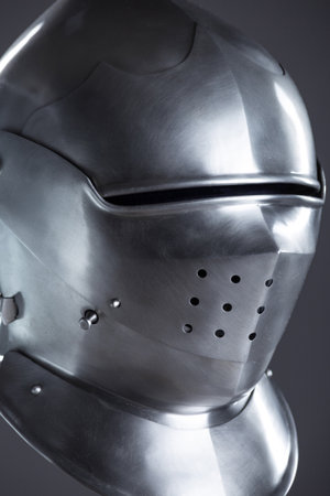 Polished Silver Medieval Armet Helmet with Perforated Visor. This shiny silver armet features a rounded skull, a protective bevor, and a visor with multiple small perforations.の写真素材