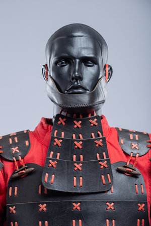 Black and Red Leather Armor Set on Mannequin. Full medieval warrior outfit with detailed stitching and metal accents.の写真素材