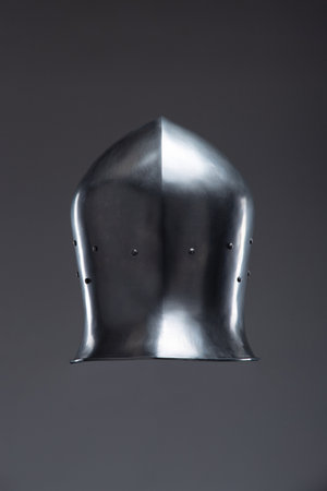 Silver Medieval Helmet with Open Face Guard. This image showcases a shiny silver helmet with an open face, featuring a rounded top and small rivets along the edges.の写真素材