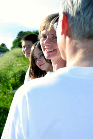 Back shot of a man with his wife and children looking at the camera