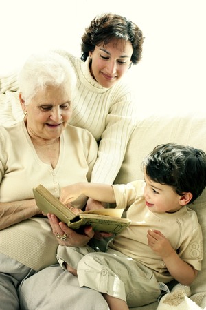 A young boy having fun learning from his grandmother and mother