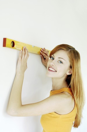 Woman measuring her house with spirit level
