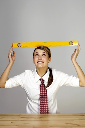 Businesswoman placing a spirit level on her head