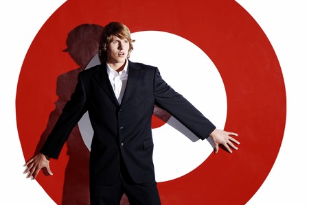 Businessman leaning against a dartboard