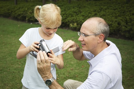 Father helping daughter with the camcorder