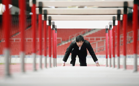 Businessman preparing to jump hurdles