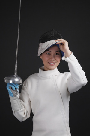 Woman with fencing foil posing for the camera