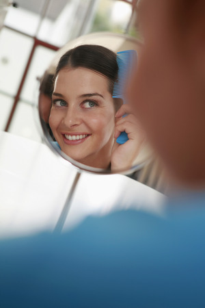 Woman combing her hairの写真素材