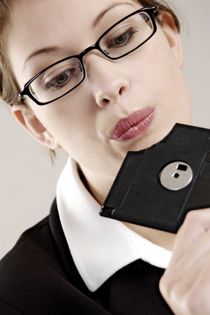 Businesswoman looking at a broken diskette