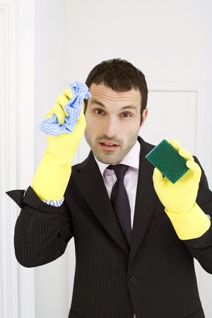 Businessman with rubber gloves, sponge and a cloth