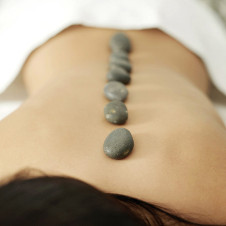 Woman receiving hot stone treatmentの写真素材