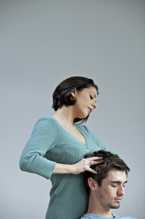 Woman giving her boyfriend a relaxing head massageの写真素材