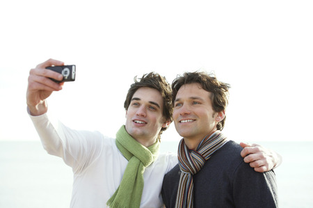 Two men taking photographs with a cell phone