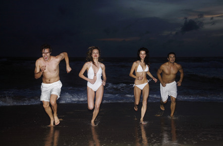 Men and women running on the beachの写真素材