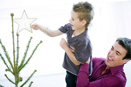 Father and son decorating the Christmas treeの写真素材