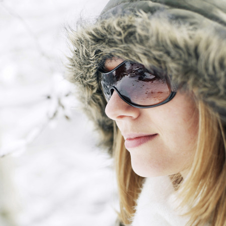 Woman in hooded jacket and sunglassesの写真素材