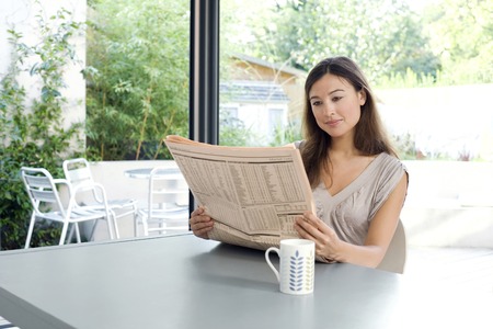 Woman reading newspaperの写真素材