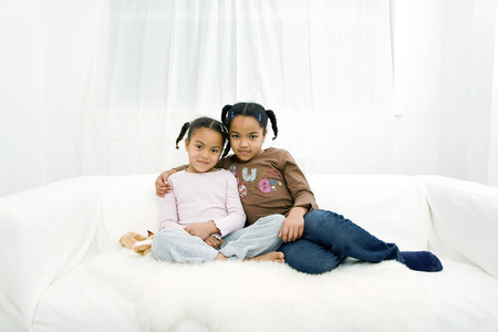 Girls posing on the couchの写真素材