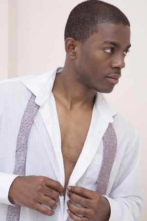 Man buttoning his shirtの写真素材