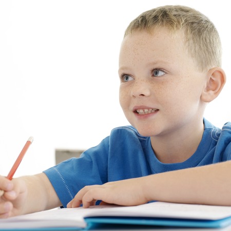 Boy looking away while holding a pencilの写真素材