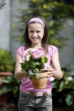 Girl holding a pot of flowersの写真素材