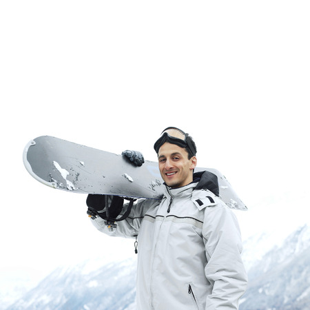 Man in warm clothing holding ski boardの写真素材