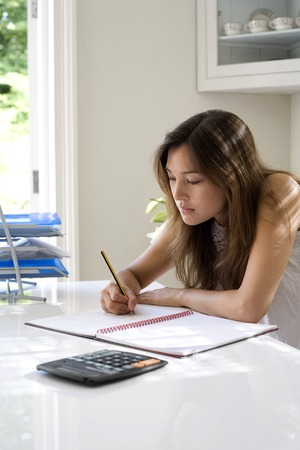 Woman working at her desk in a home officeの写真素材