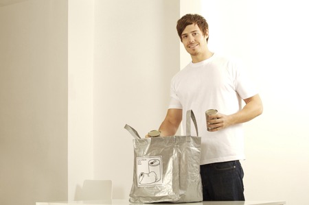 Man with cans and plastic bag for recycling